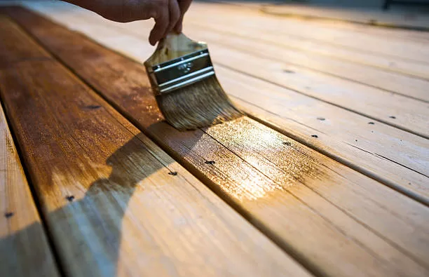 Paint Brush applying primer to wood