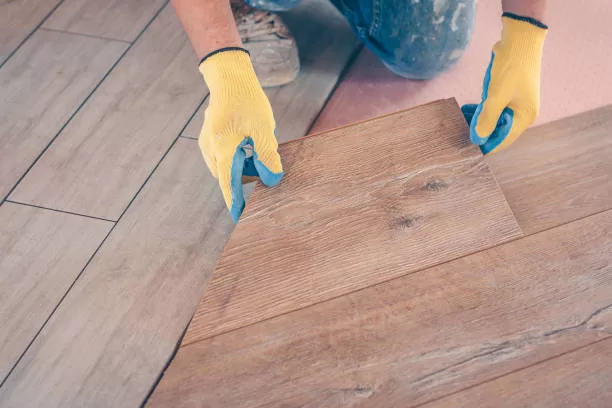 Professional installation of floor covering, the worker quickly and qualitatively mounts a laminate board