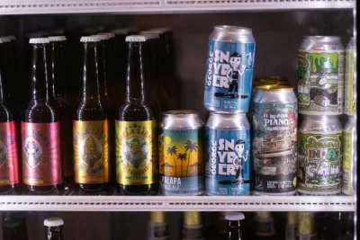 mini fridge in a man cave filled with beer bottles