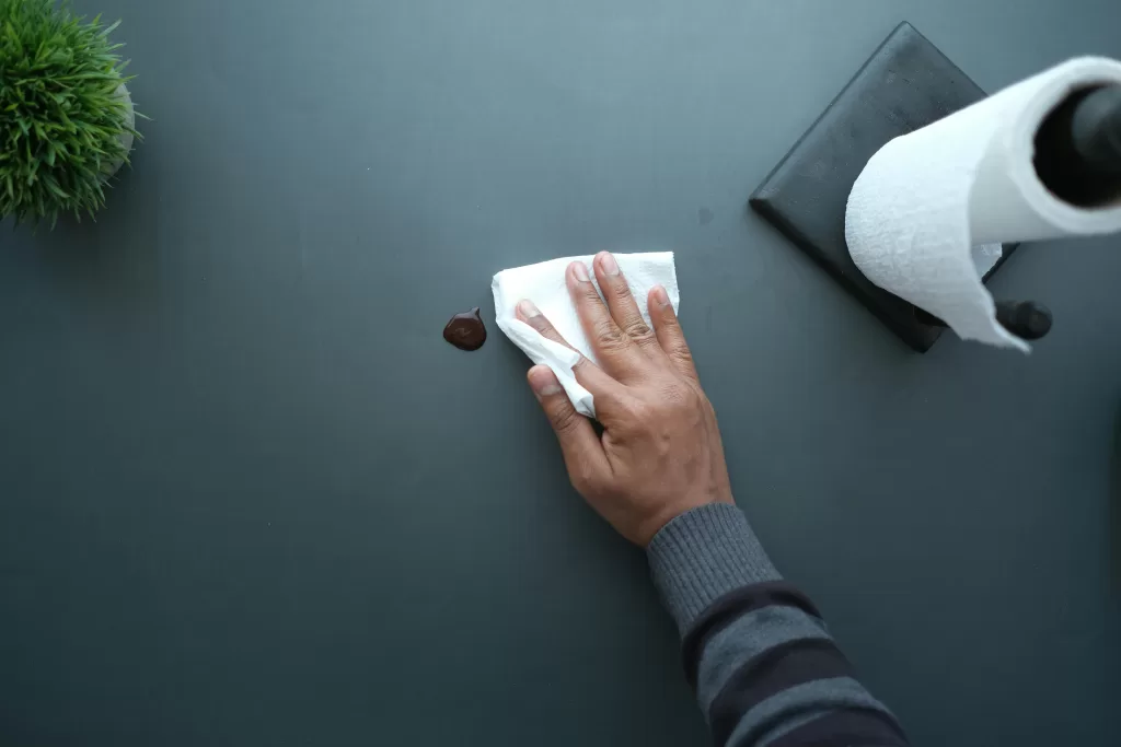 persons hand wiping a spill with papertowel