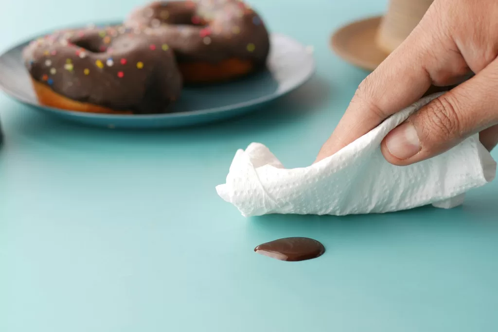 a hand cleaning chocole off countertop