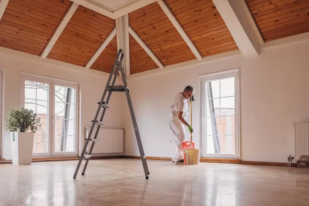 One man, mature male painter painting a wall with paint roller, indoors in a house.