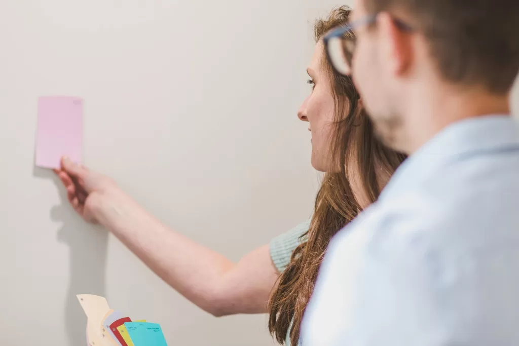 couple holding color up to wall to see how it will look painted
