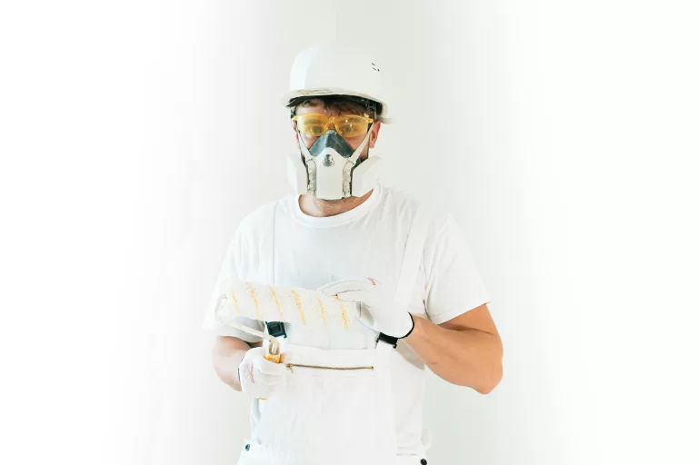 Professional painter holding paint bruish wearing mask