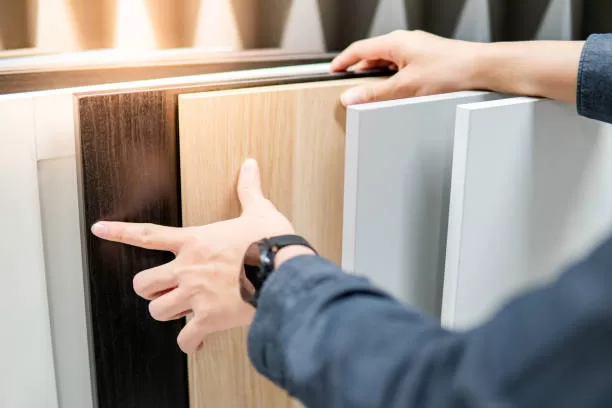 Male hand choosing cabinet panel materials or countertops for built-in furniture design. Shopping furniture and decoration. Home improvement concept