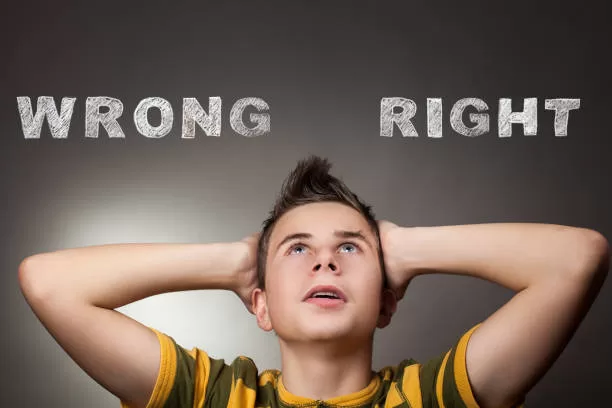 Young boy looking up at wrong and right words in background
