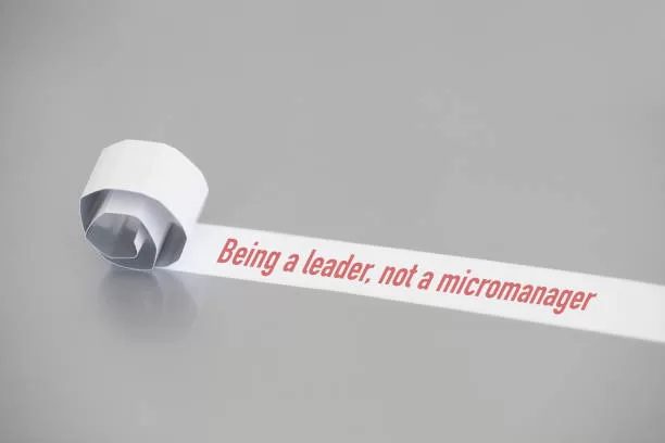 Being a leader, not a micromanager written under torn paper.