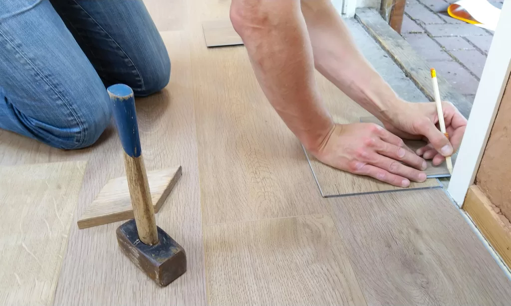 Man measuring and cutting floor