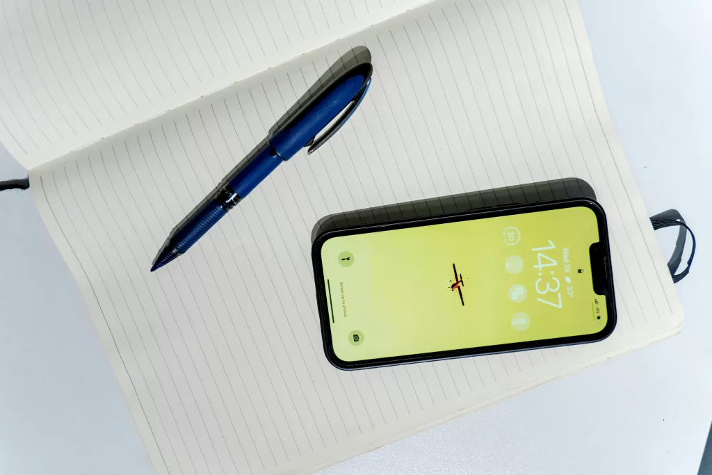 Notebook with pen and cell phone on top of it