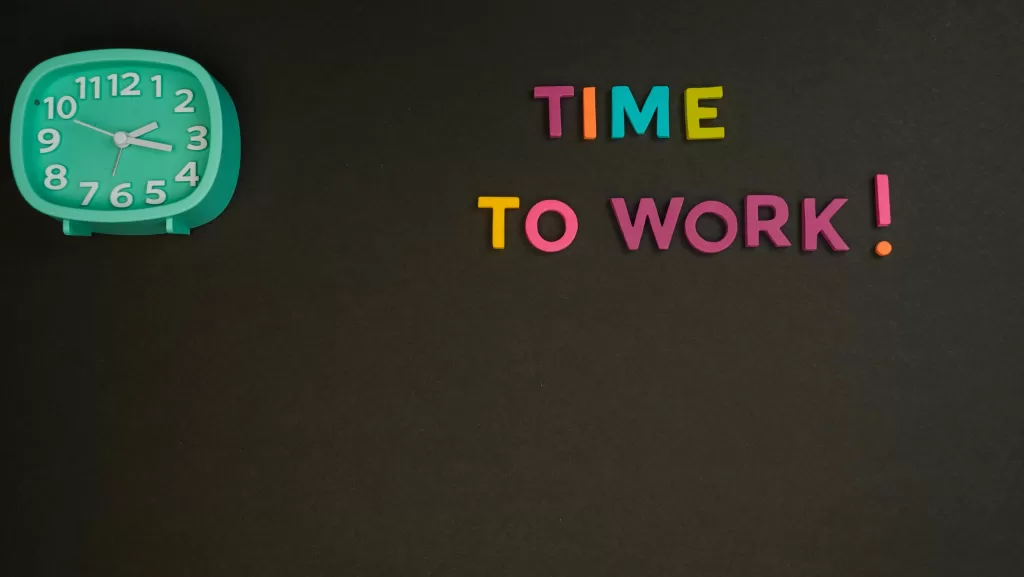 A clock with words saying time to work next to it