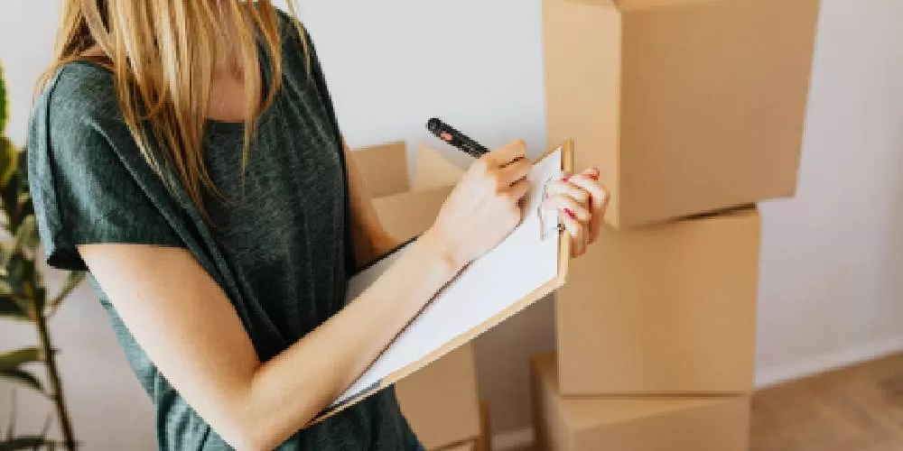 Woman writing on clipboard preparing for home upgrade