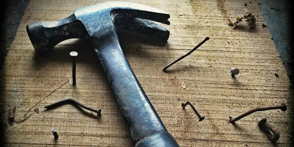 Hammer on wood with bent used nails