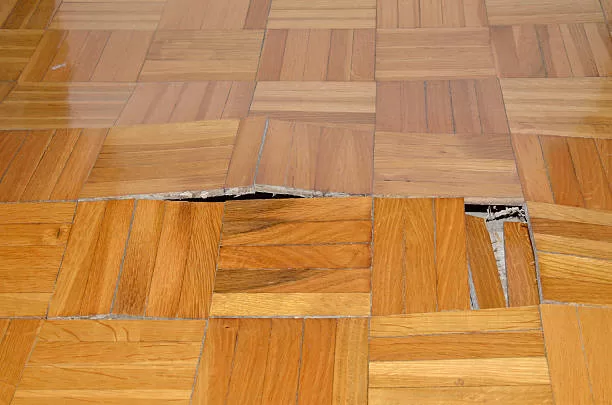 Wooden floor in apartment with floor damaged by destructive elements such as wet, moisture, water.