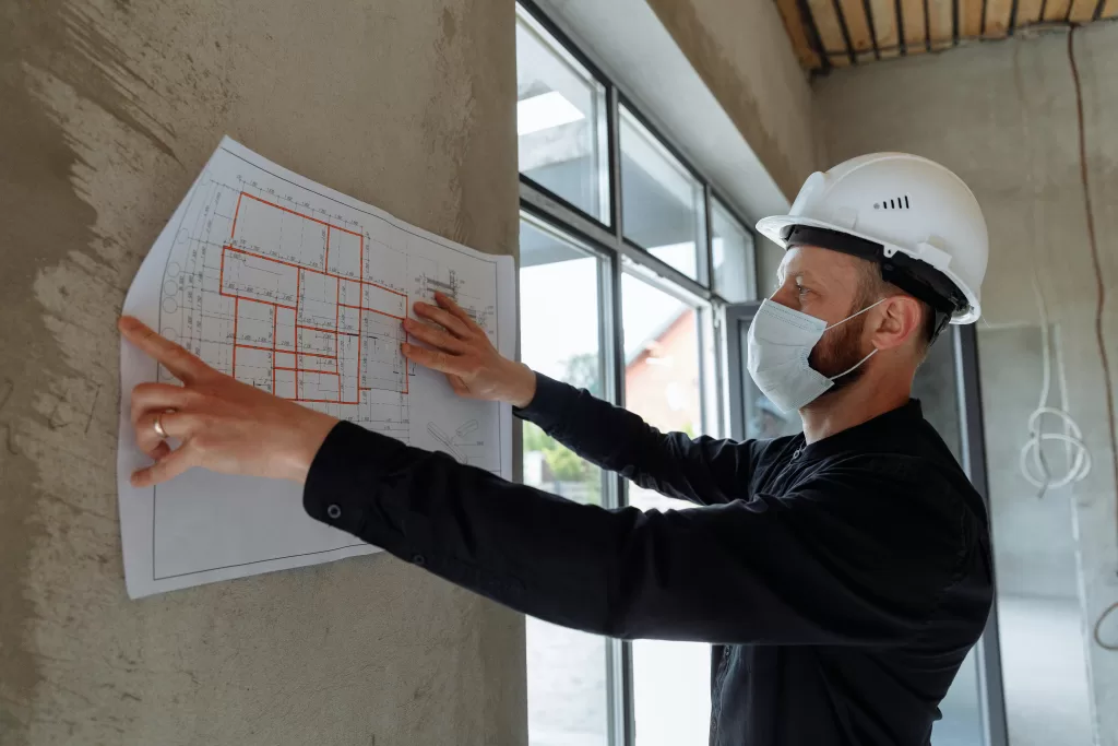 contractor lookin at layout against wall