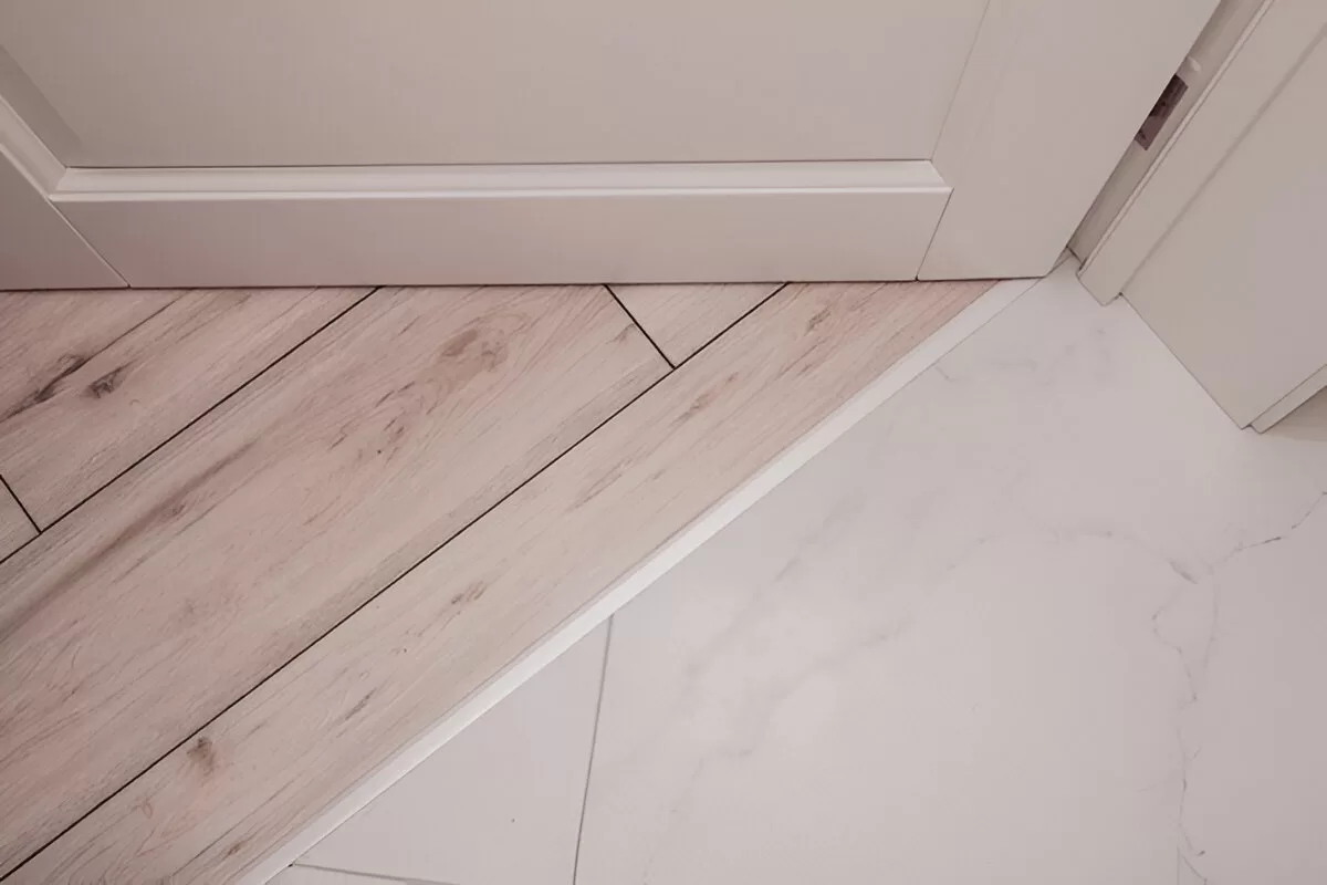Low‑profile transition from hardwood to tile in a Toronto renovation.