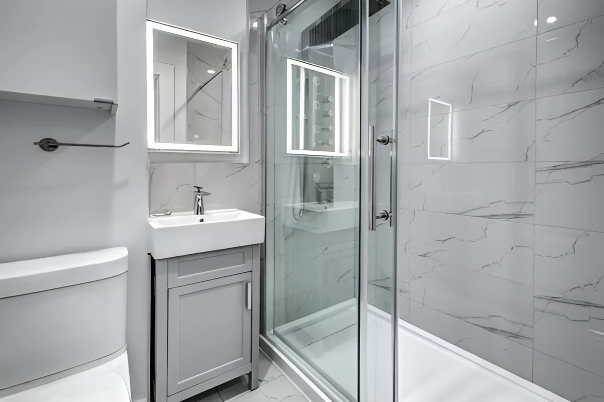 Condo bathroom remodel in Toronto featuring curbless shower and porcelain tile.