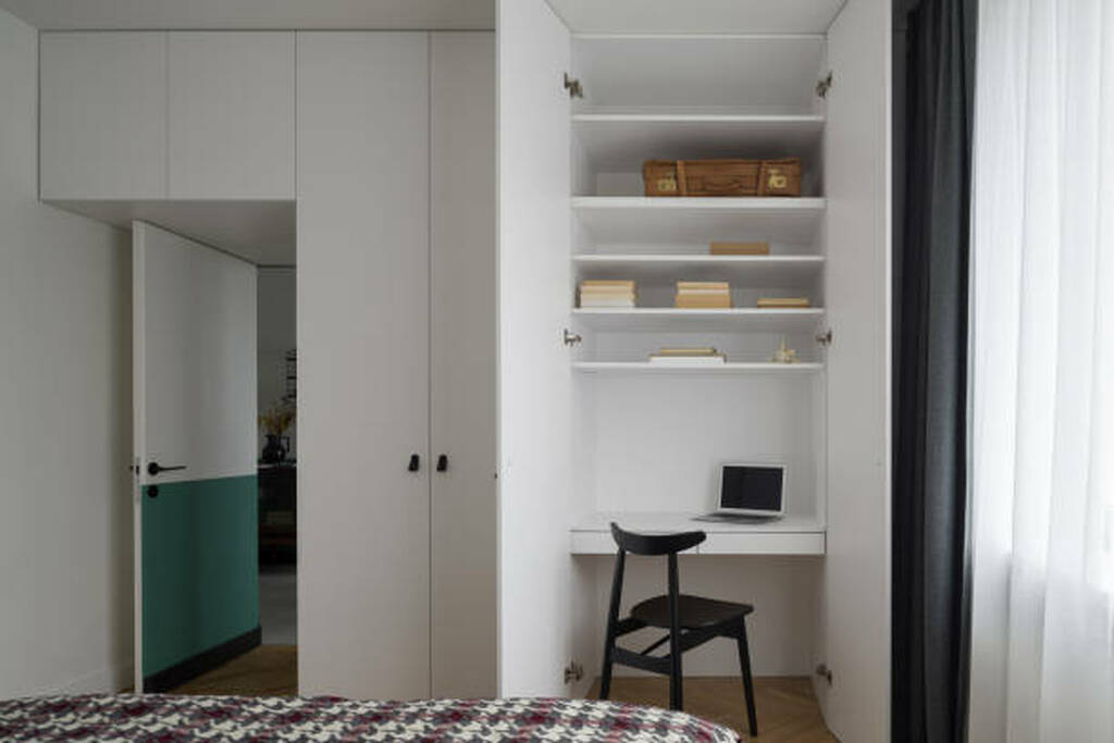 Compact Toronto bedroom converted into a home office with desk by the window.