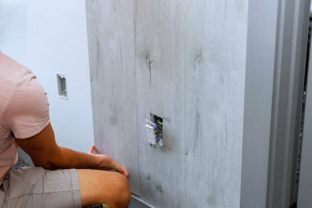 Licensed electrician installing additional outlets and data cabling in a home office renovation.