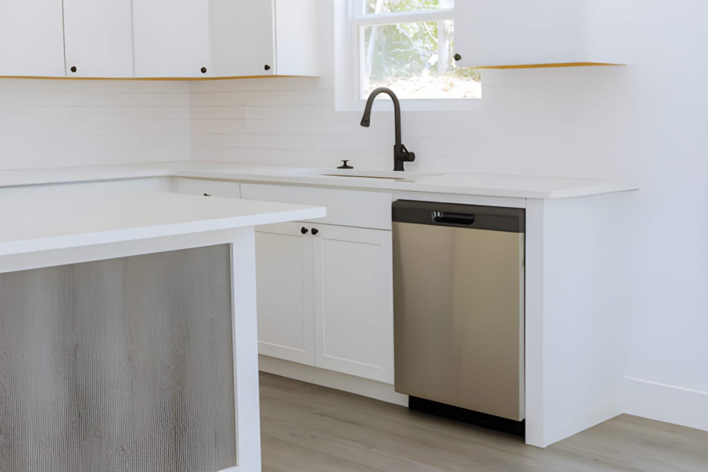 Panel ready dishwasher installed beside a white farmhouse sink in a renovated kitchen.