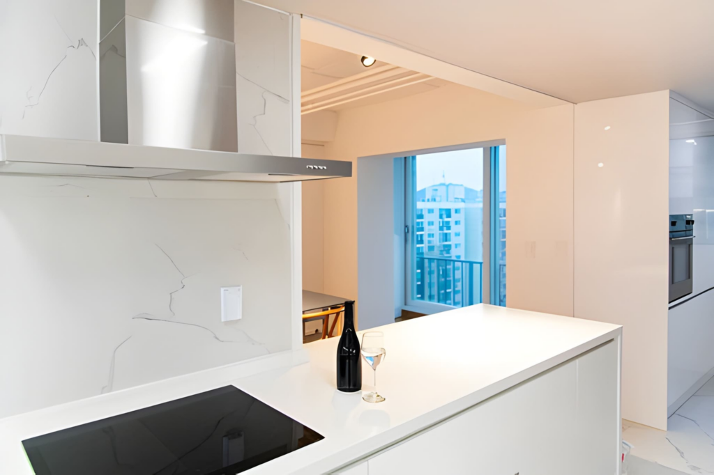 Bright Toronto condo kitchen with white cabinets, peninsula, and city view
