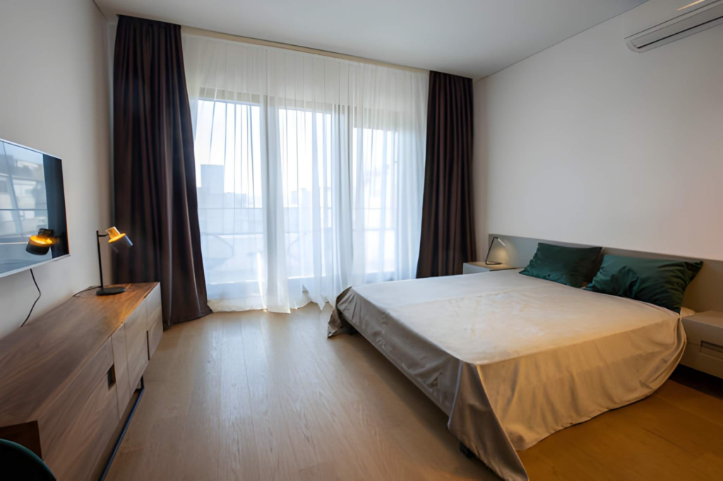 Quiet Toronto bedroom with thick curtains, and upholstered bed for sound and warmth.