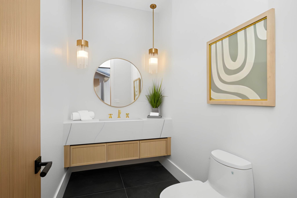 Small Toronto powder room layout with wall-mounted vanity and round mirror.