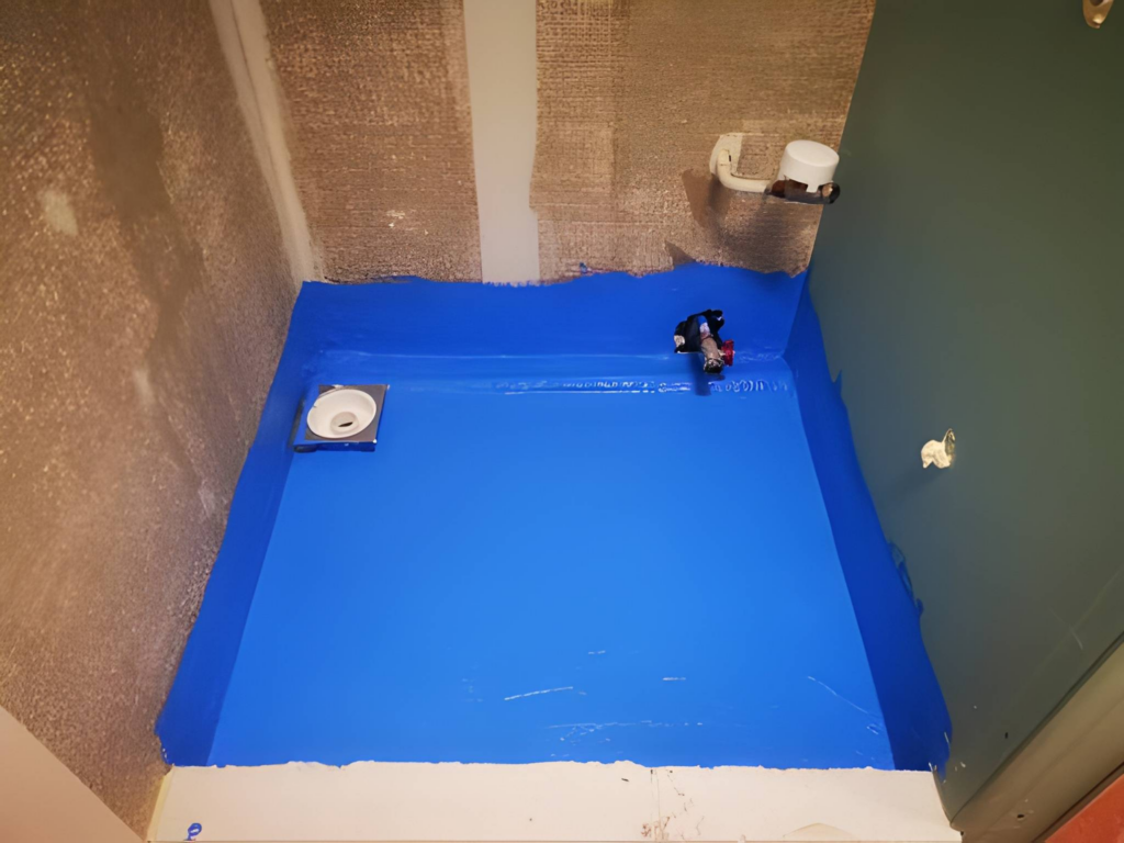 Basement shower under construction with waterproofing membrane on the walls.